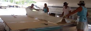 Positioning the first sheet of biaxial fiberglass on the bimini foam