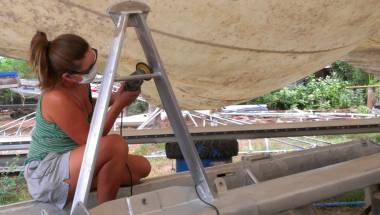 Amanda sitting on the boom so she can polish the forebeam