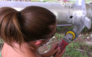 Amanda polishing the fiddly spreader bases on the mast