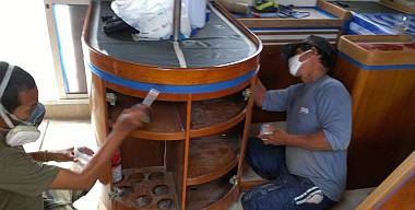 Baw and Pla brushing epoxy on high wear areas of the galley