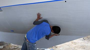 Baw roughing up the hulls so the antifouling sticks