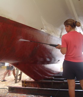 Amanda having fun cleaning the hull with the borrowed power sprayer..