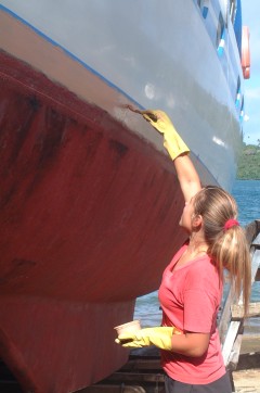 Amanda applies epoxy primer to her newly raised waterline