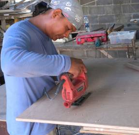 Houa cutting the new bunk in his workshop