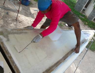 Houa epoxying down the final 2 layers of glass on starboard bow