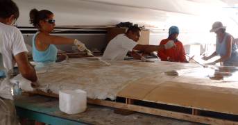 Fiberglassing the lower sheet, tied down to the mold