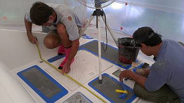 Jon measuring the foredeck while Pla prepares it for gelcoat