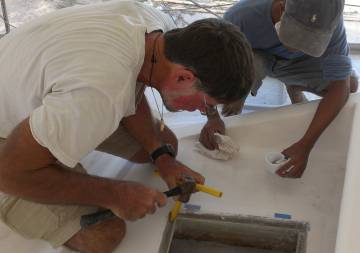 Jon & Nut tapping a new foredeck gutter drain into place 