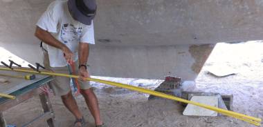 Jon slicing PVC pipe in half to become bolt-rope holders