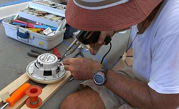 Jon's hat soldering wires on our old outdoor speakers