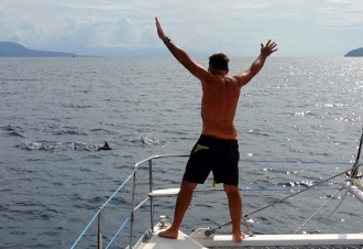 Jon waving to dolphins swimming off our bows
