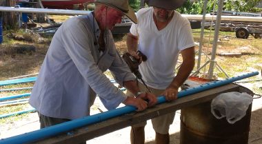 Kim & Jon drilling oversized holes in the mast's electrical conduit