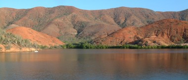 The beautiful green-fringed red hills of Laguna Grande