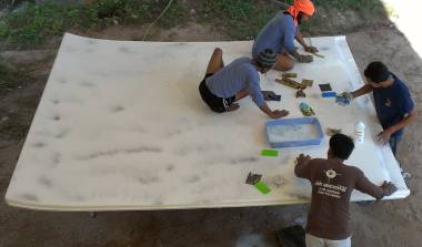 Baw & his men sanding the underside of the flipped over bimini