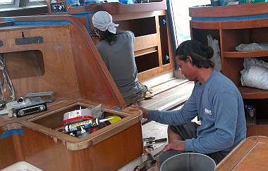 Houa works on the teak trim while Lek epoxies some bare wood