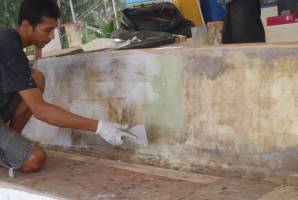 Max smearing epoxy mud over the newly glassed wall