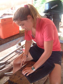 Amanda cuts new rubber flaps (from truck tire flaps) to seal the saildrives.