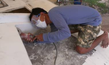 Nut grinding off a sharp edge of fiberglass under the "eyebrows"