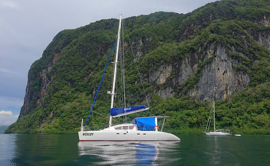 Anchored under sheer karst cliffs of Imorgue Island