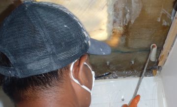 Pla laying reinforcing glass under the deck in port fwd head