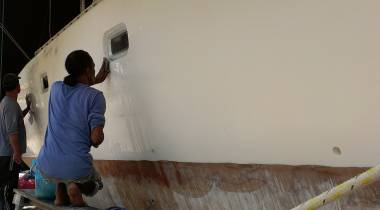 Pla & Lek sanding the gelcoat dots on the starboard topsides