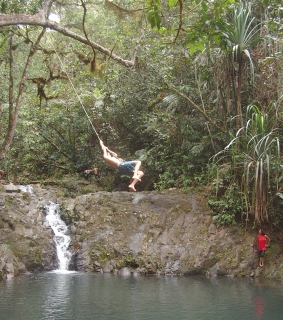Chris takes the plunge from a rope swing into a pool.
