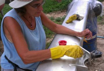 Sue putting paint stripper on the fiddly bits of the mast