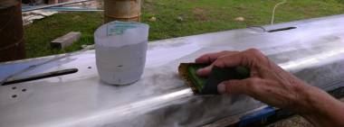 Sue wet-sanding the mast with 400 and then 600 grit paper