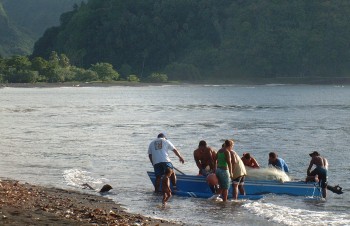 Fishermen return with the boat to the beach in Tautira, Tahiti-Iti