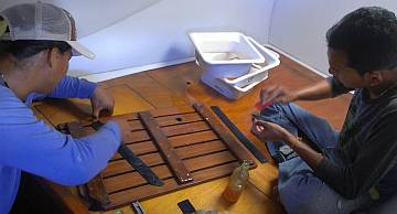 Heru and Baw gluing neoprene on the shower grates